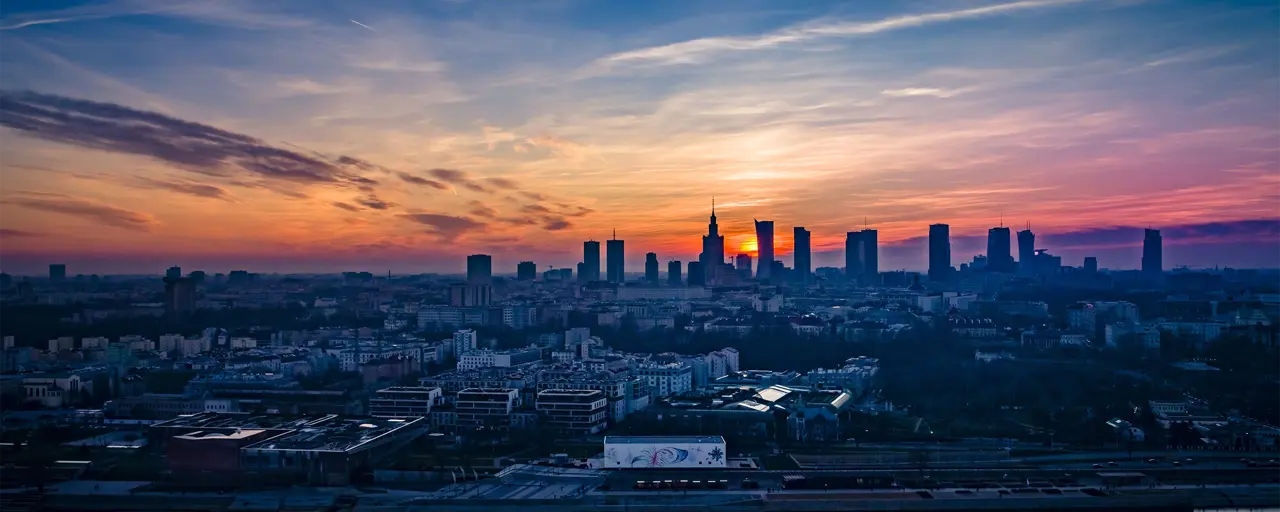 Sky view of the city with the sun setting in far distance