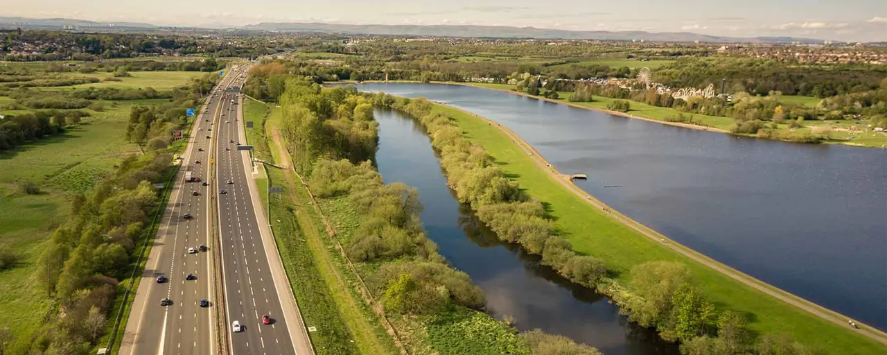 View of a motorway with greenery surrounding the motorway.