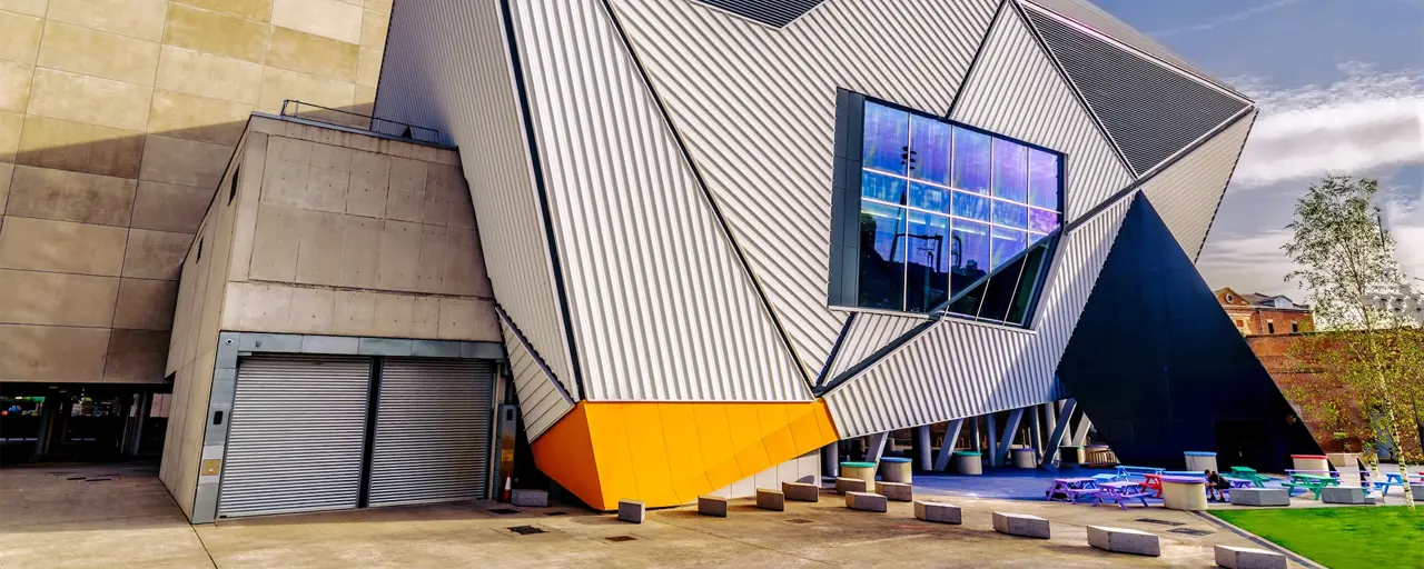 Modern, corrugated building of dynamic angles against a blue sky