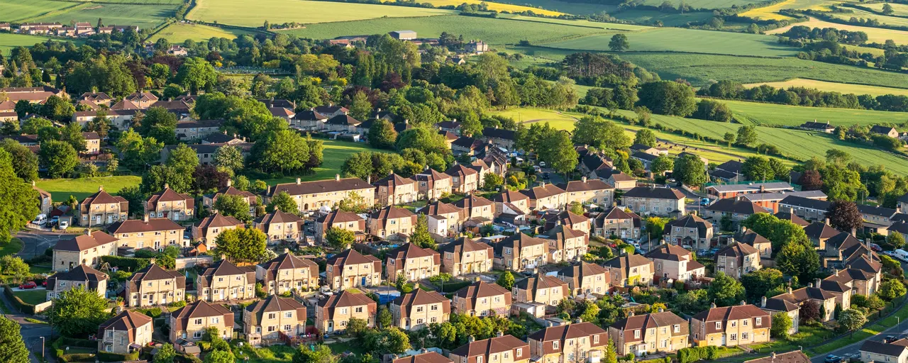 Sky view of the houses in field of greenery that are supporting the net zero