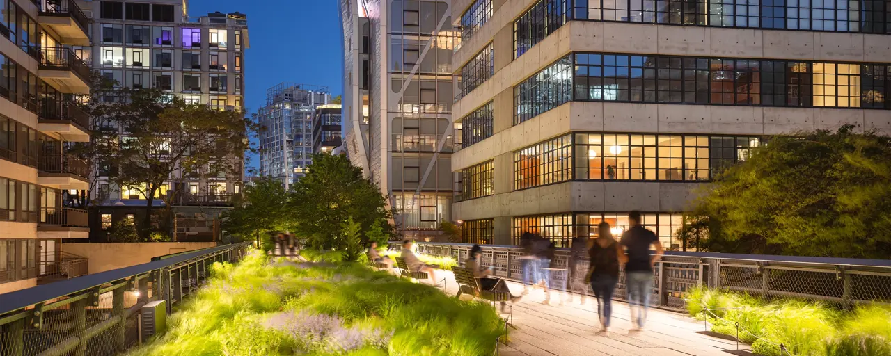 View of buildings late in the evening with pedestrians walking through city