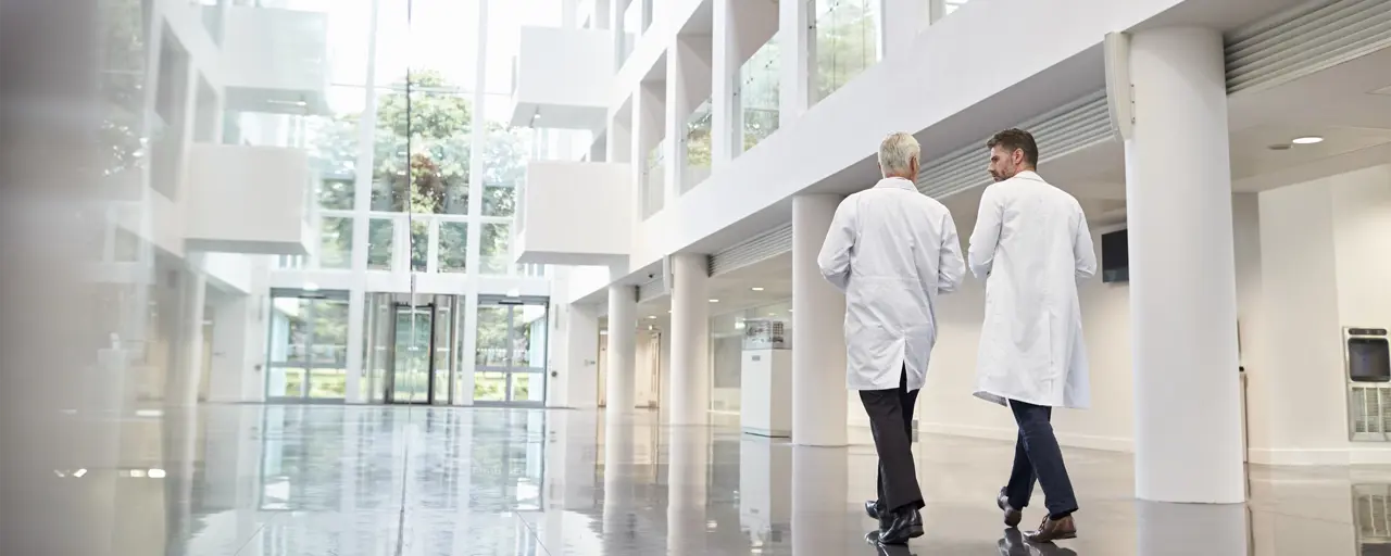 Two people in white coats in hospital facility