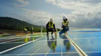 Team contractor, male engineer and female technicians wearing safety uniform, talking about installing plan, check the working system and maintenance solar panel of solar power plant to produce electricity on the roof of factory building. Industrial of renewable energy. Power generation from solar energy.