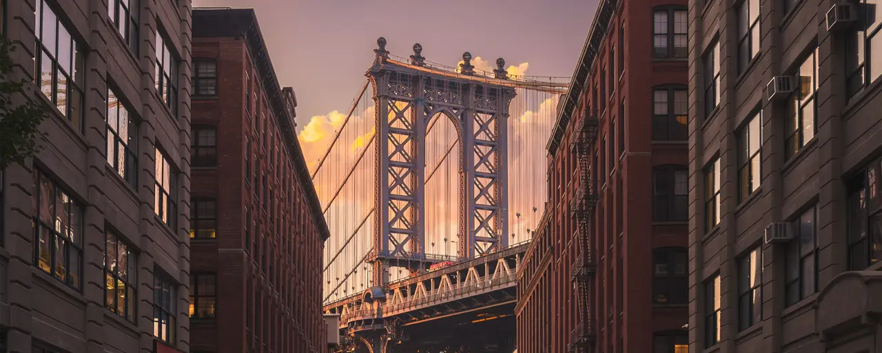 New York city street view with bridge and Empire State Building in the far distance