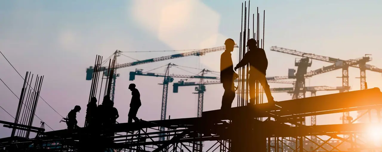 Construction workers working together on site with the sun setting