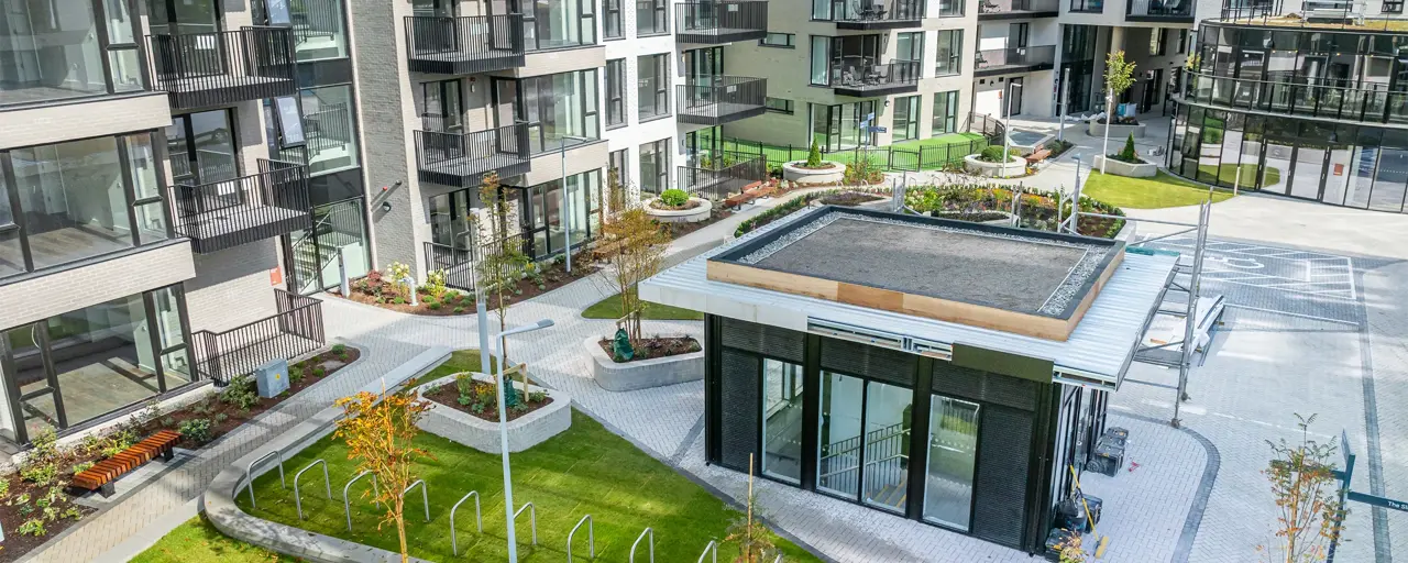 Portrait of new modern block of flats, with a mini block with stairs and green plants/ grass in the center