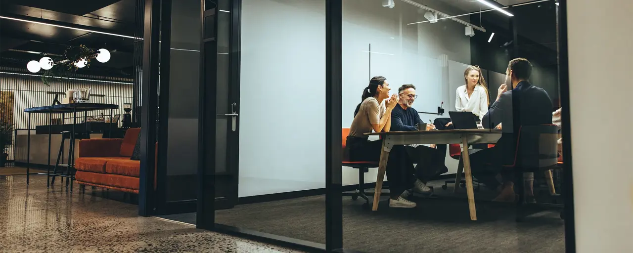 Coleagues sitting around a table in a meeting room