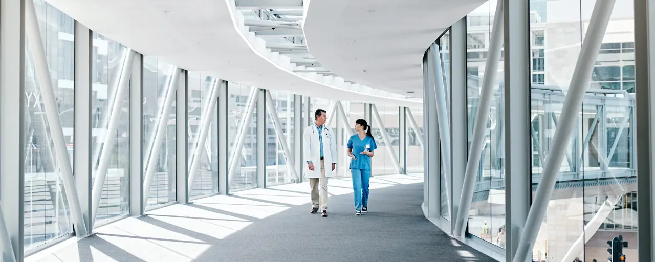 Two doctors walking down hallway.