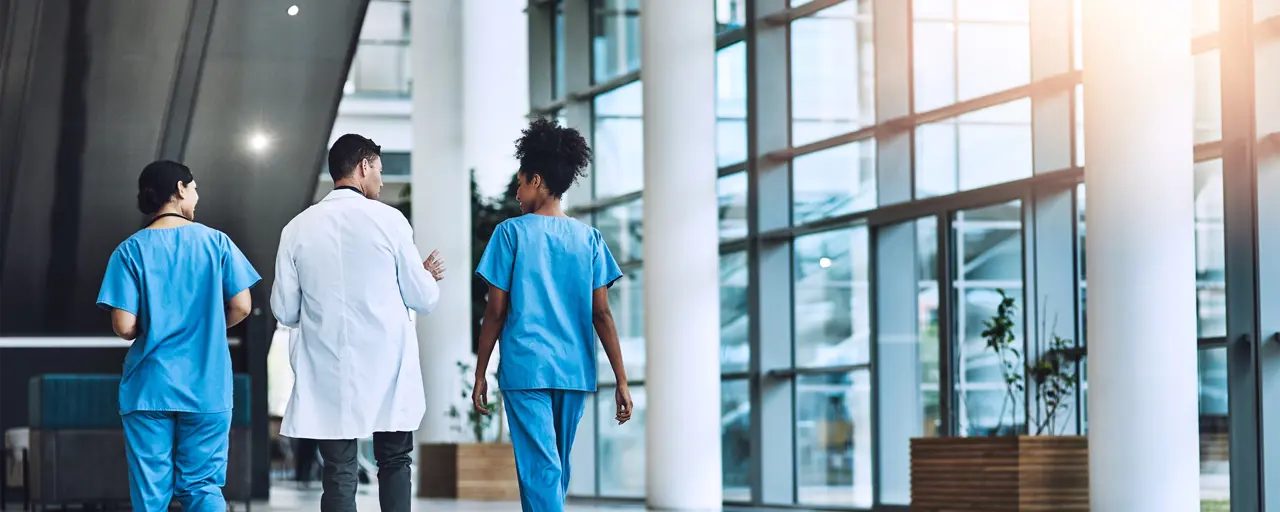 Three medic's walking and talking in hallway.