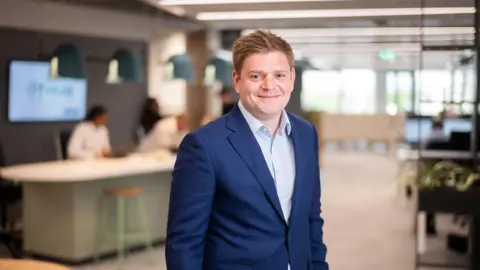 James Corrigan, UK Managing Director, Infrastructure, smiling in a softly lit office interior