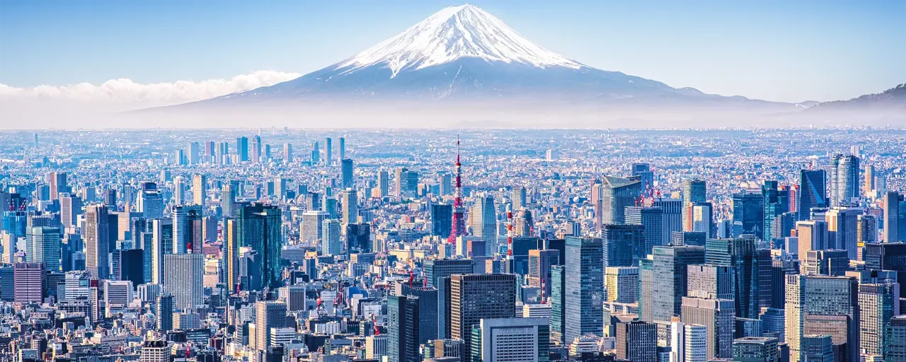 Aerial view of Mount Fuji, Tokyo Tower and modern skyscrapers in Tokyo on a sunny day.