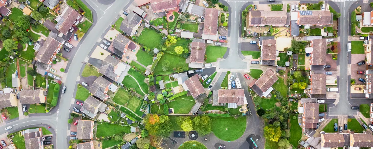 Aerial view of houses in a village, showing street layout and gardens