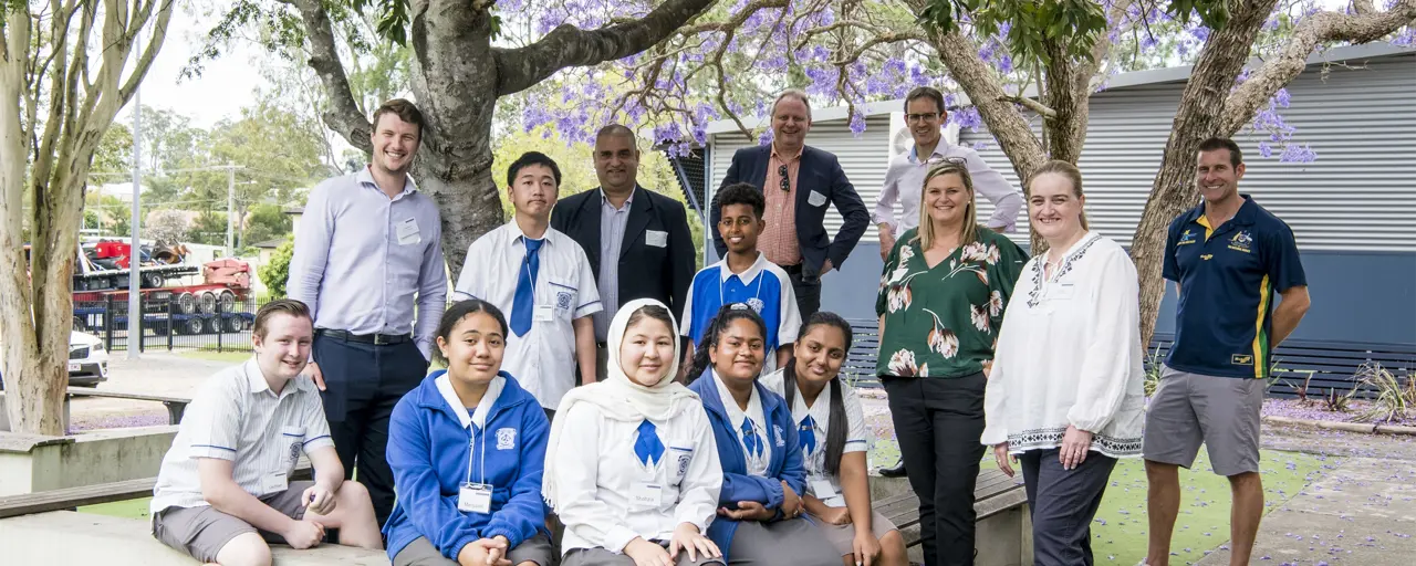 Group of school children and teachers surrounded by trees