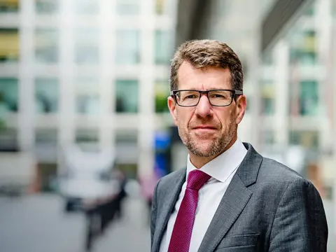 Tim Tapper, UK and Europe Expert Lead, outside in front of a glass building