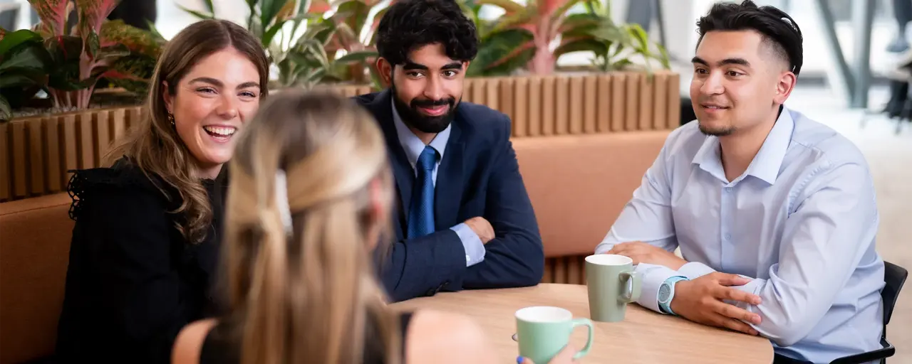 A group of young employees having a casual chat in the break room.