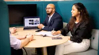 A group of employees having a meeting in blue booths.