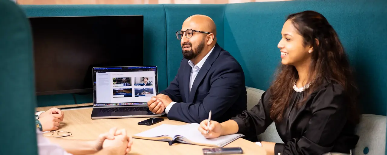 A group of employees having a meeting in blue booths.