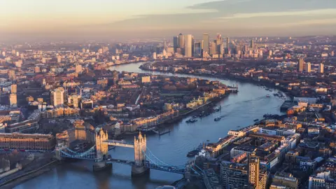 Aerial view of London at sunset with buildings surrounding the Thames