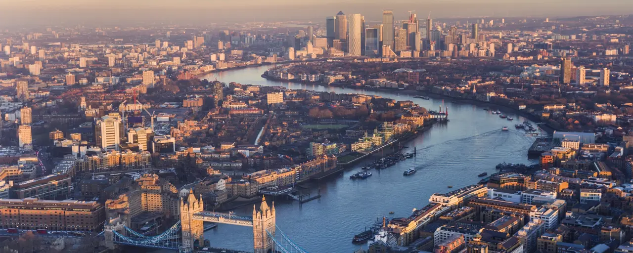 Aerial view of London at sunset with buildings surrounding the Thames