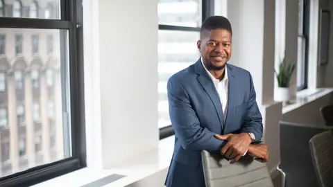 Wayne Lambert, Director of Supplier Diversity, US, in an office with white walls and beige chairs and a pot plant